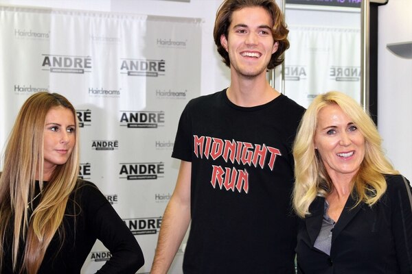 Drei Menschen mit langen, gepflegten Haaren posieren in einem modernen Friseursalon.